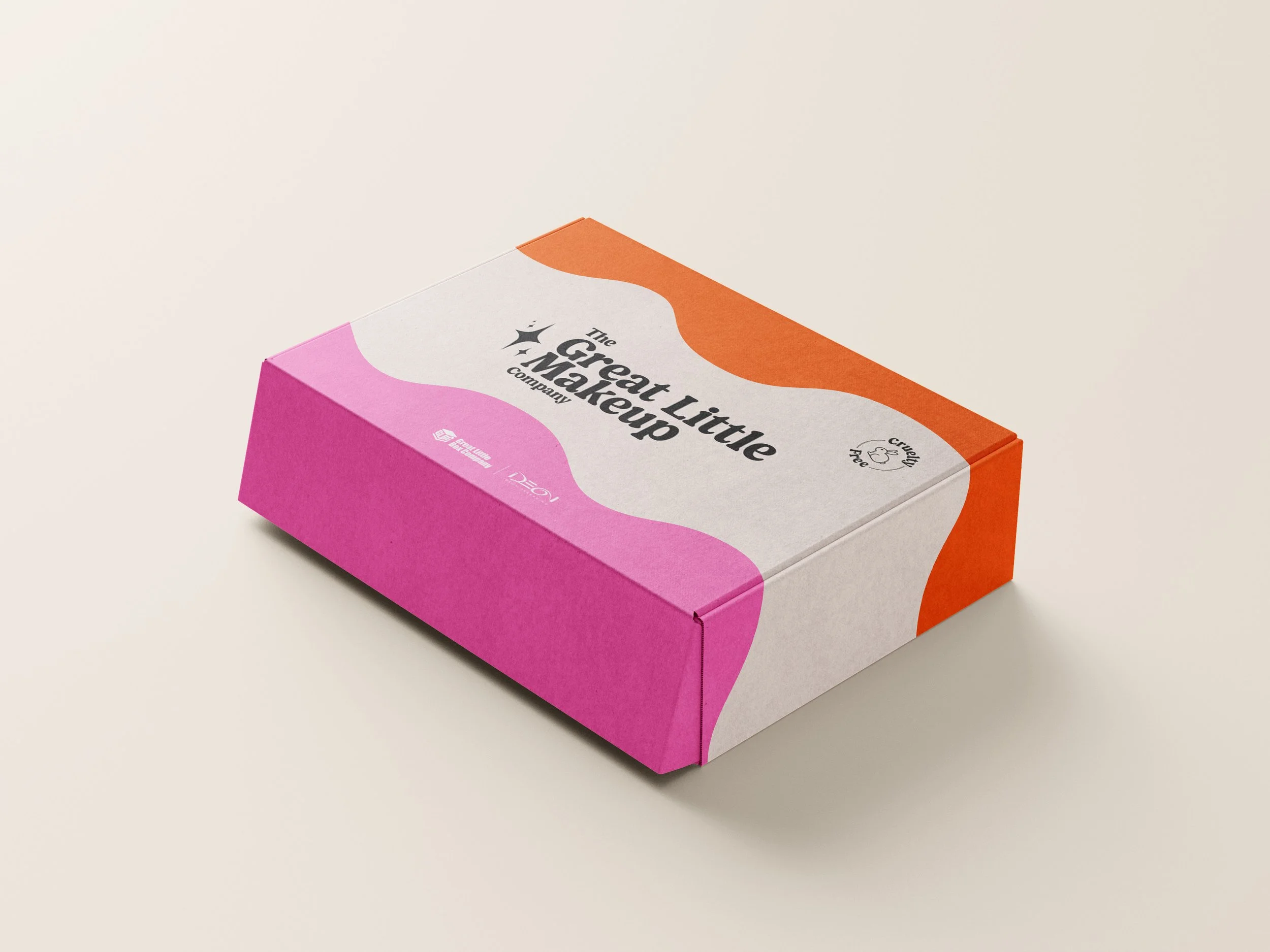 Colorful box labeled 'The Great Little MakeUp Company' with pink, orange, and white design, and an eco-friendly symbol, on a white background.