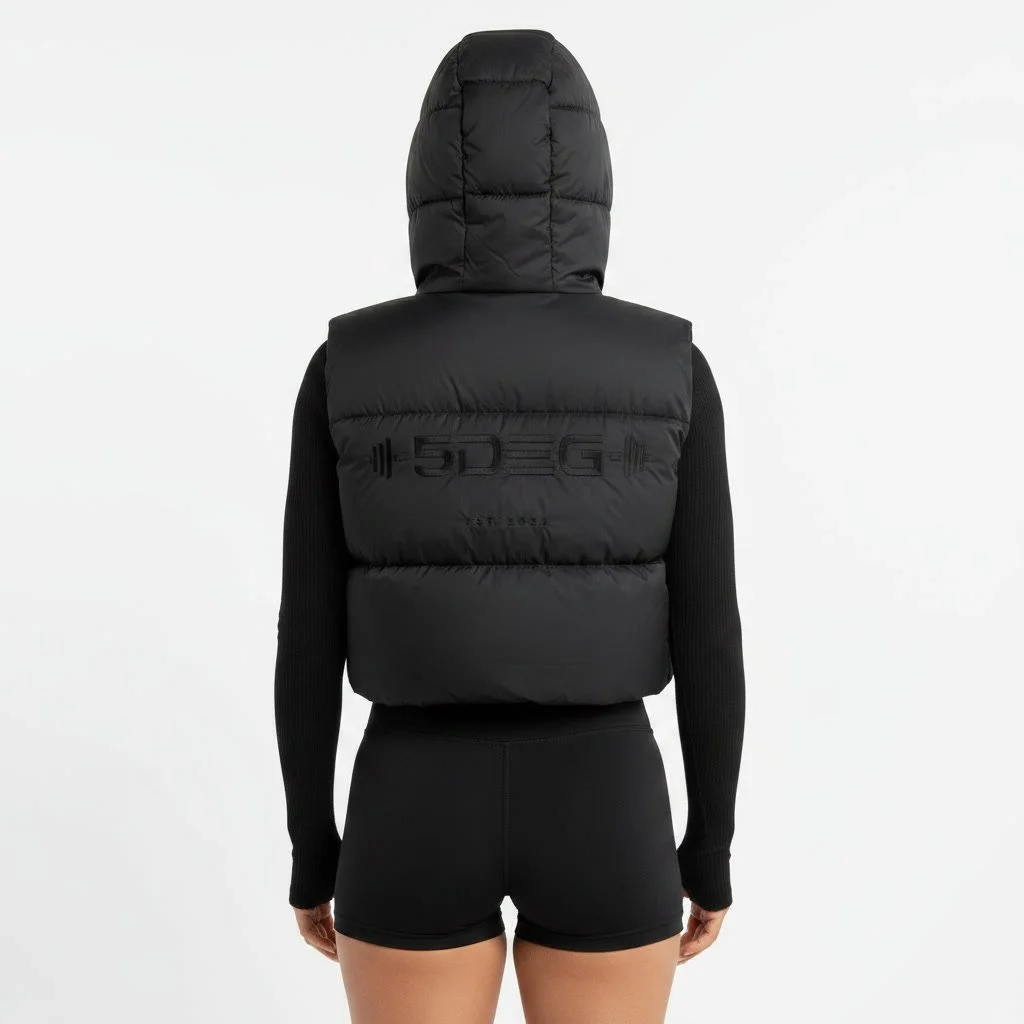 gemini-2.5-flash-image_same_female_model_same_black_cropped_puffer_vest_oversized_hood_black_ribbed_lon-0.jpg