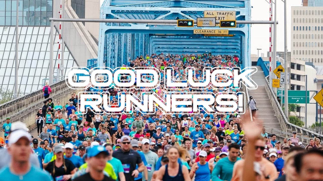 Large crowd running over the Main Street Bridge in Downtown Jacksonville for the Gate River Run with Good luck Runners in white letters overlayed