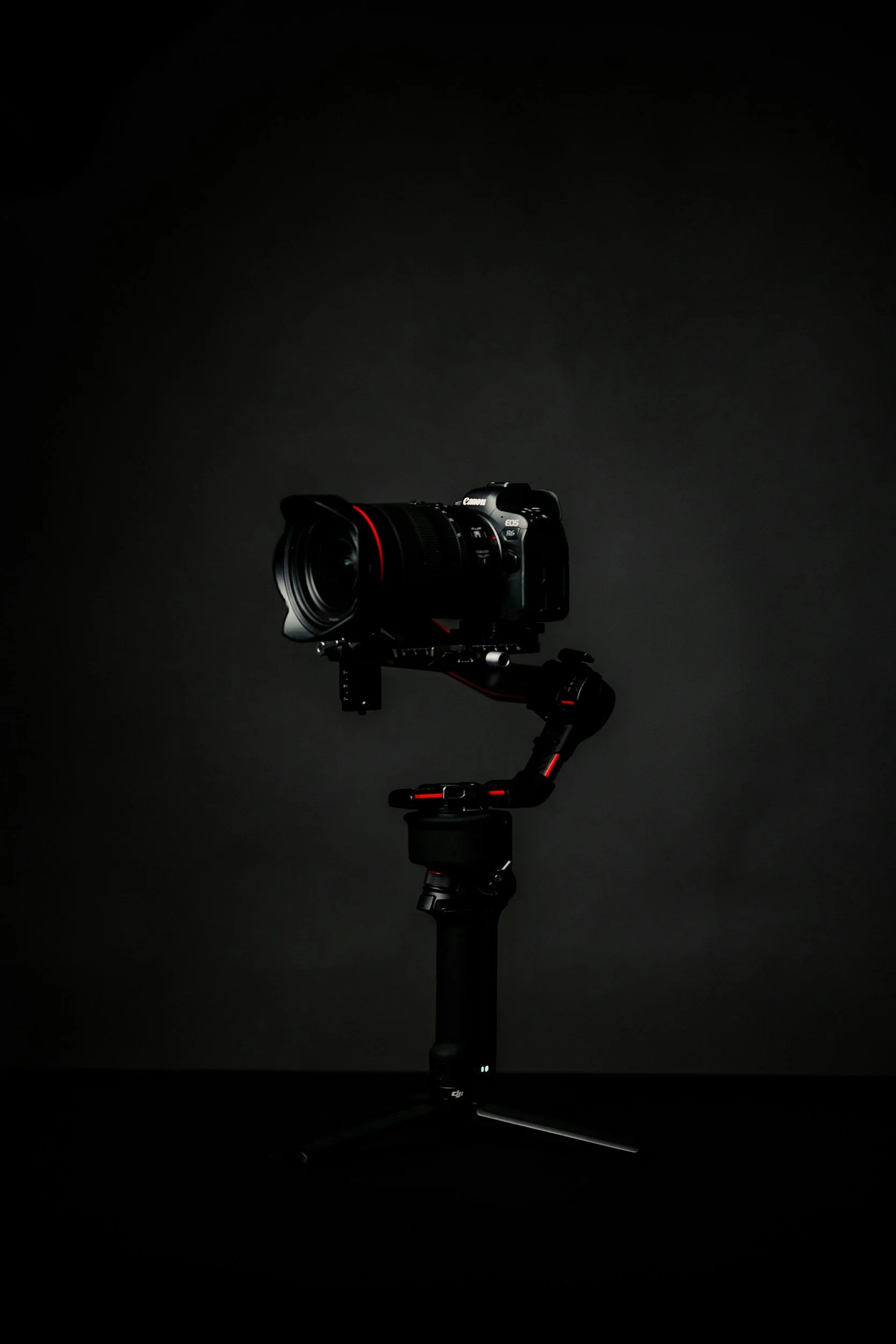 A professional camera mounted on a camera stabilizer against a dark background.