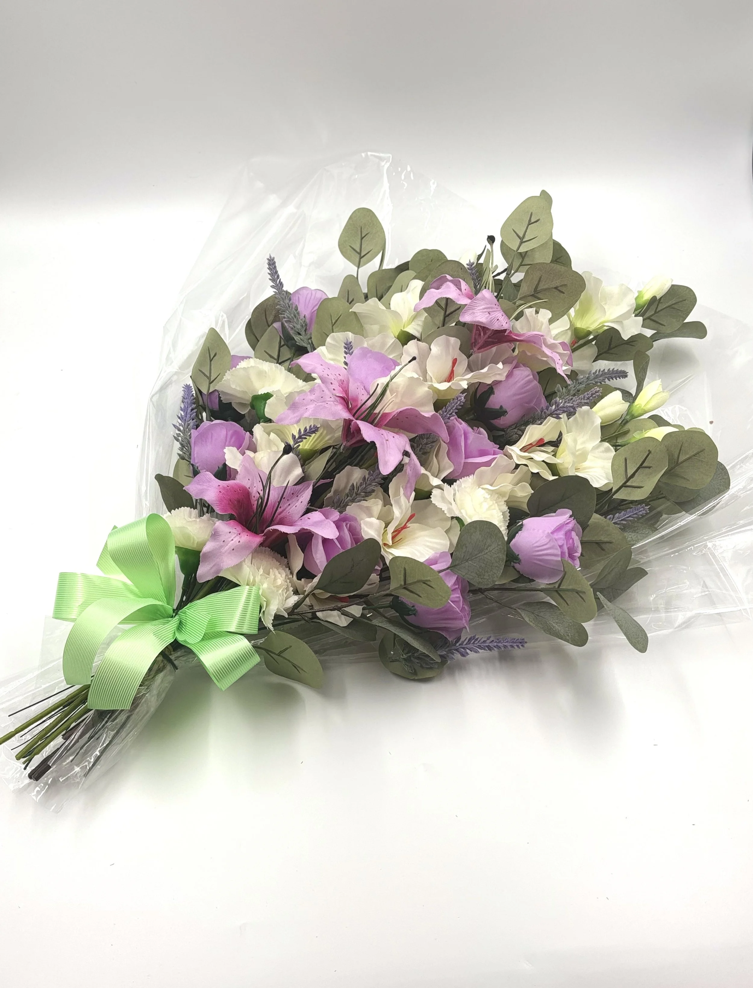 PRESENTATION SHEAF
Sheaf of Gladioli, Lilies & Roses
A Graceful Presentation Sheaf featuring tall white gladioli, soft pink lilies, and classic roses, hand-tied with foliage for a natural finish. This piece is designed to be laid flat and offers a st