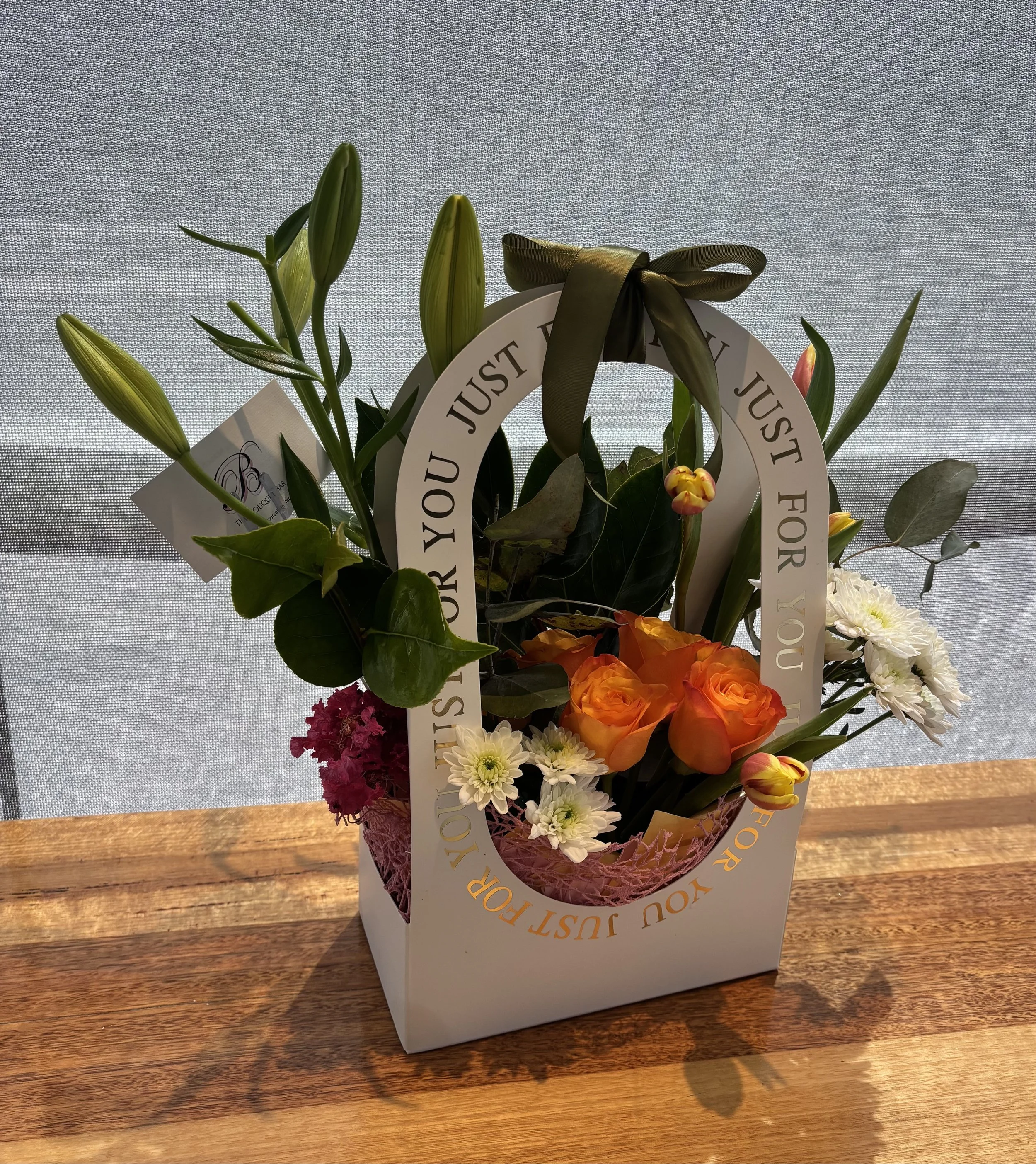  JUST FOR YOU FLORAL ARRANGEMENT
Chic Floral Gift Bag with orange roses, yellow tulips, and white chrysanthemums enriched with pink lilies arranged for modern gifting, handcrafted by The Bouquet Bar Adelaide. (Click on Image to Enquire.)
