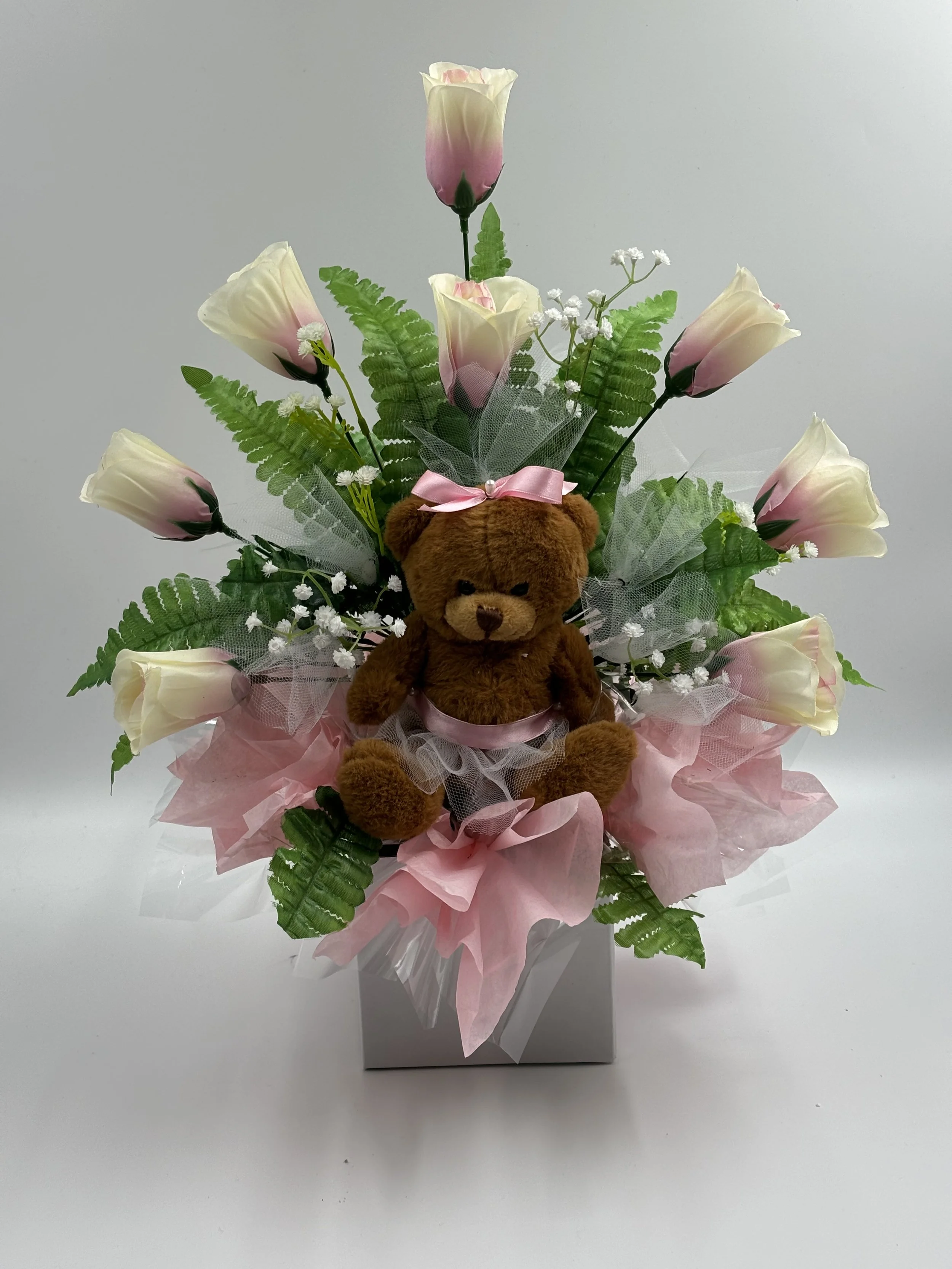 TEDDY BEAR BOX ROSES  DISPLAY
Teddy Bear in a Floral Box with 8 Roses, Fern & Gypsophila
A Heartwarming Gift Arrangement featuring a soft teddy nestled in a floral box, surrounded by eight fresh roses, soft gypsophila, and lush green fern. A charming