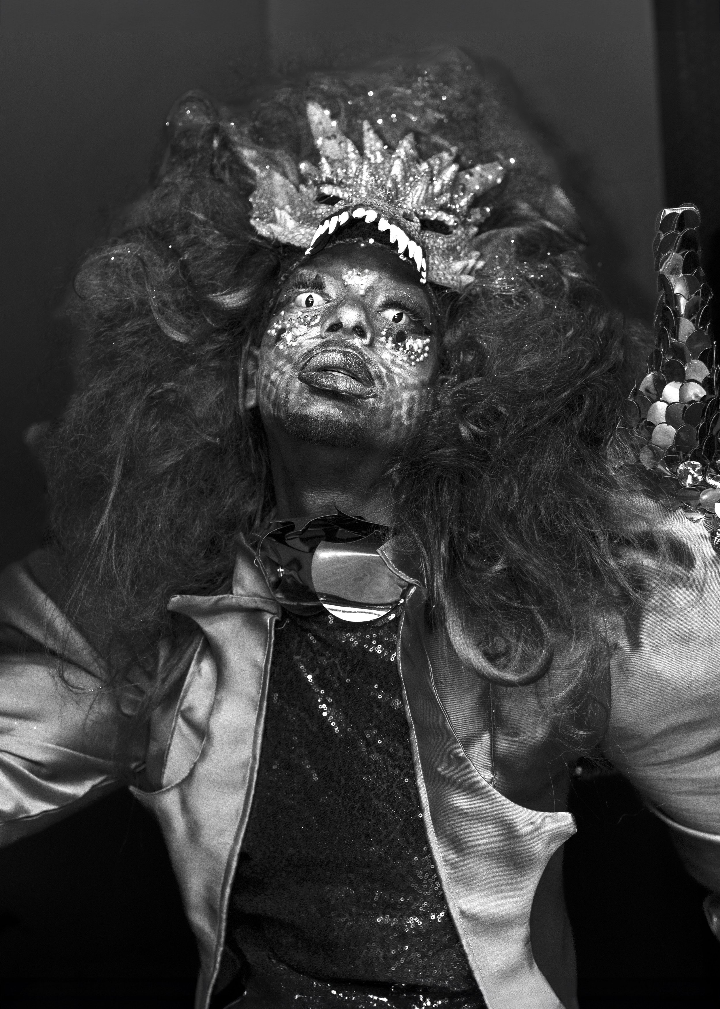 Person in elaborate costume with curly hair and intricate face paint. Image by portrait photographer.