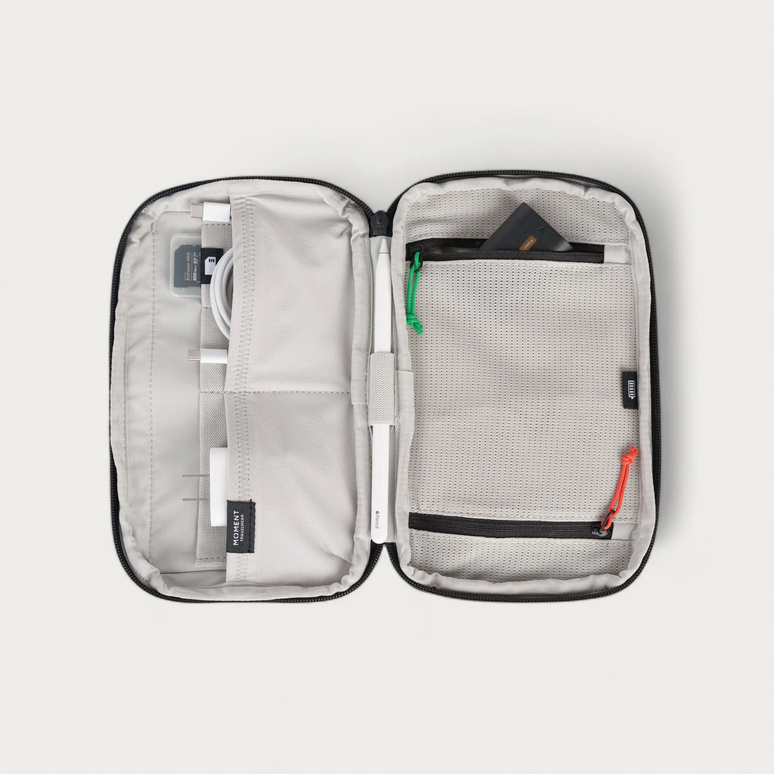 Open gray and black travel organizer with multiple compartments containing electronic accessories.