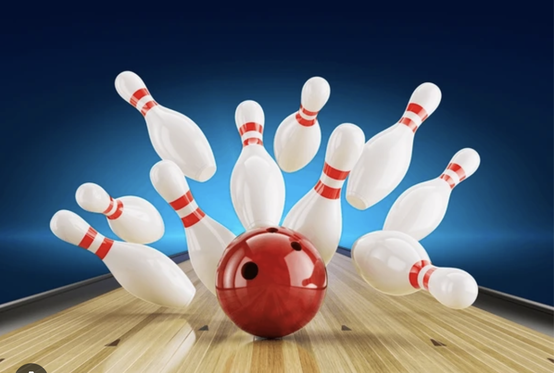 Four smiling members at a bowling alley, each holding a bowling ball, posing in front of the lanes
