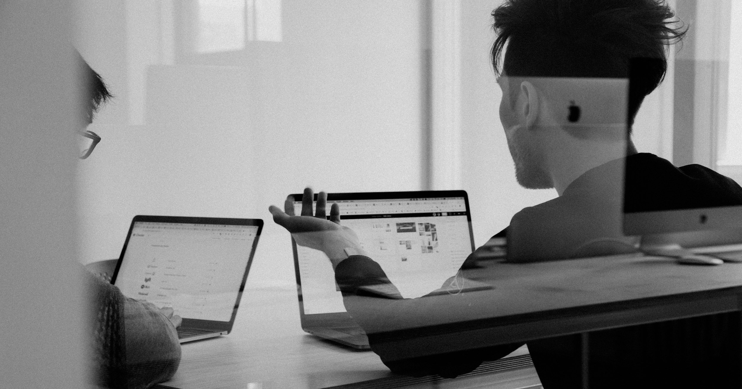 二人のビジネスマンが「しんさくラボ」のホームページから問い合わせをしようとしているシーン