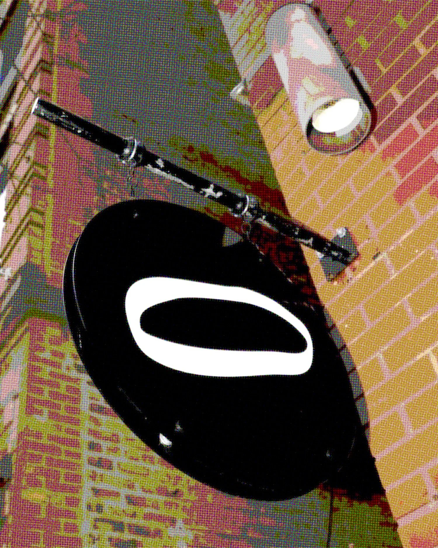 A modern minimalist black and white logo sign leading into a brick allyway