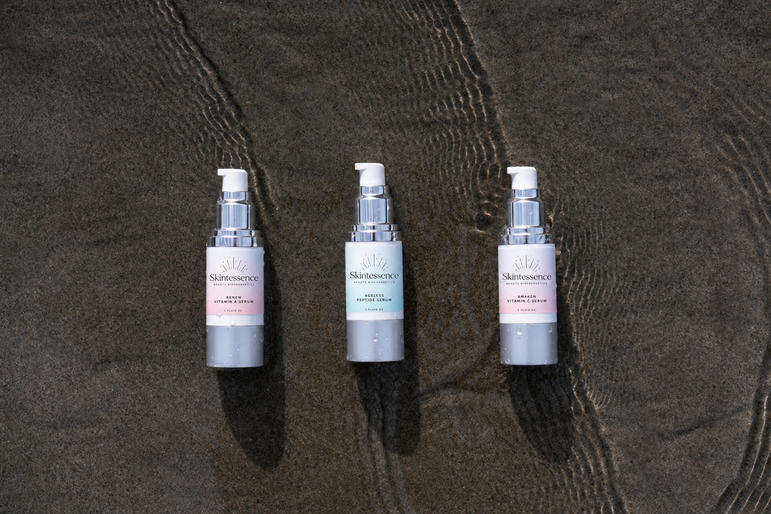 an image of 3 serums on the sand