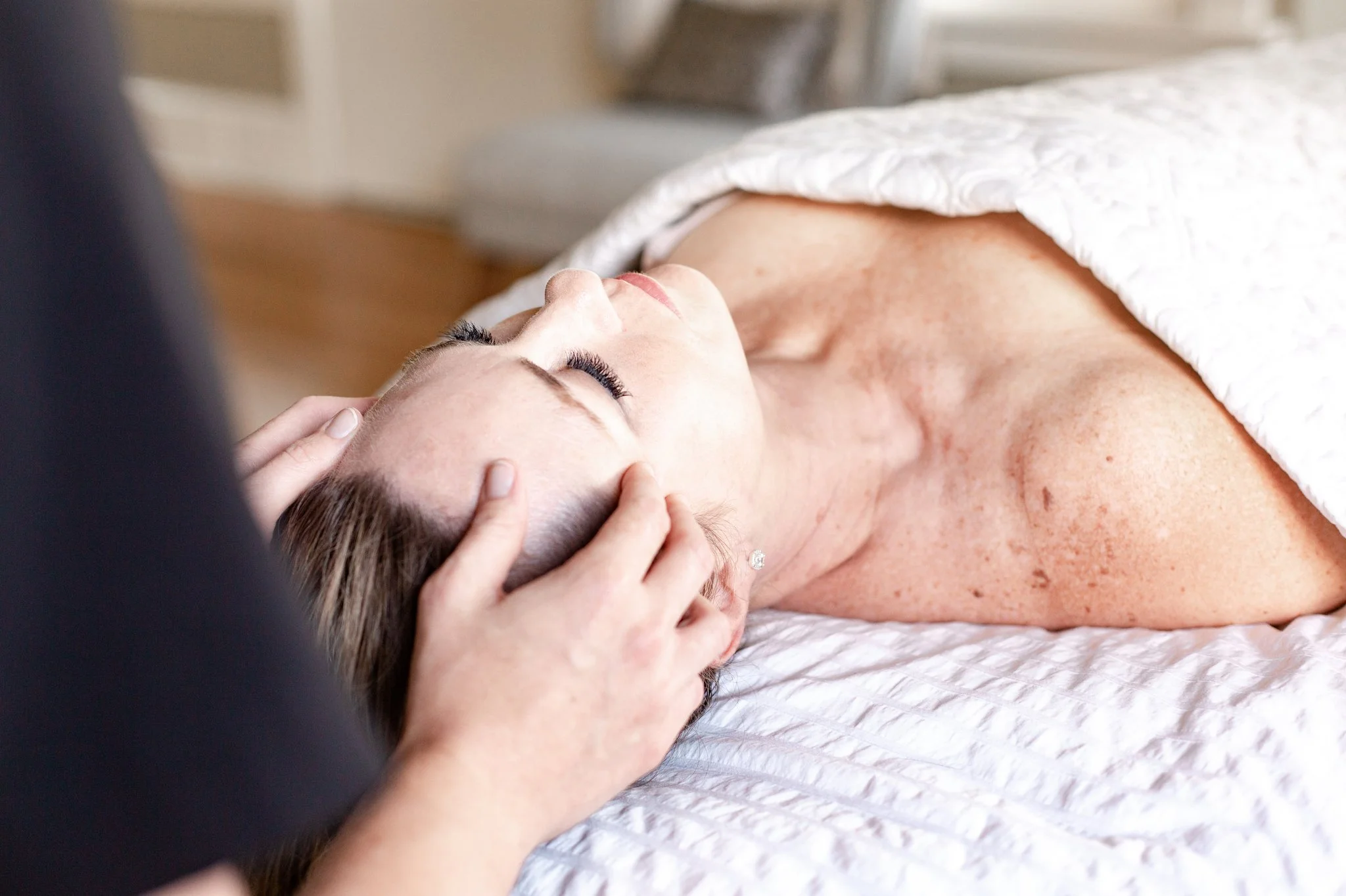 An image of a woman laying on a facial table