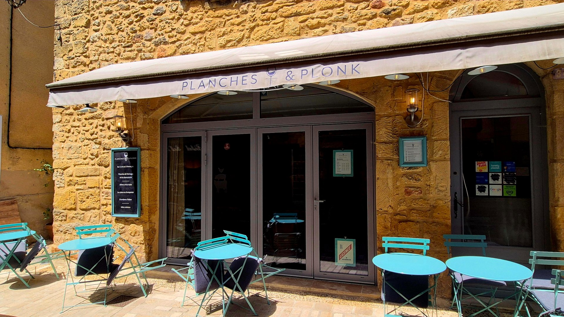 Planches et Plonk Wine and Cheese Bar in Belves with turqoise chairs on the exterior