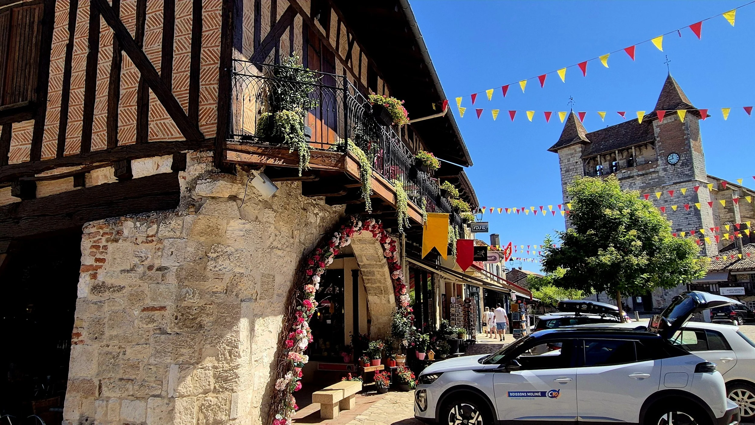 Half-timbered buildings and colourful streets leading towards the Church of Notre-Dame in the medieval bastide of Villeréal, Lot-et-Garonne.