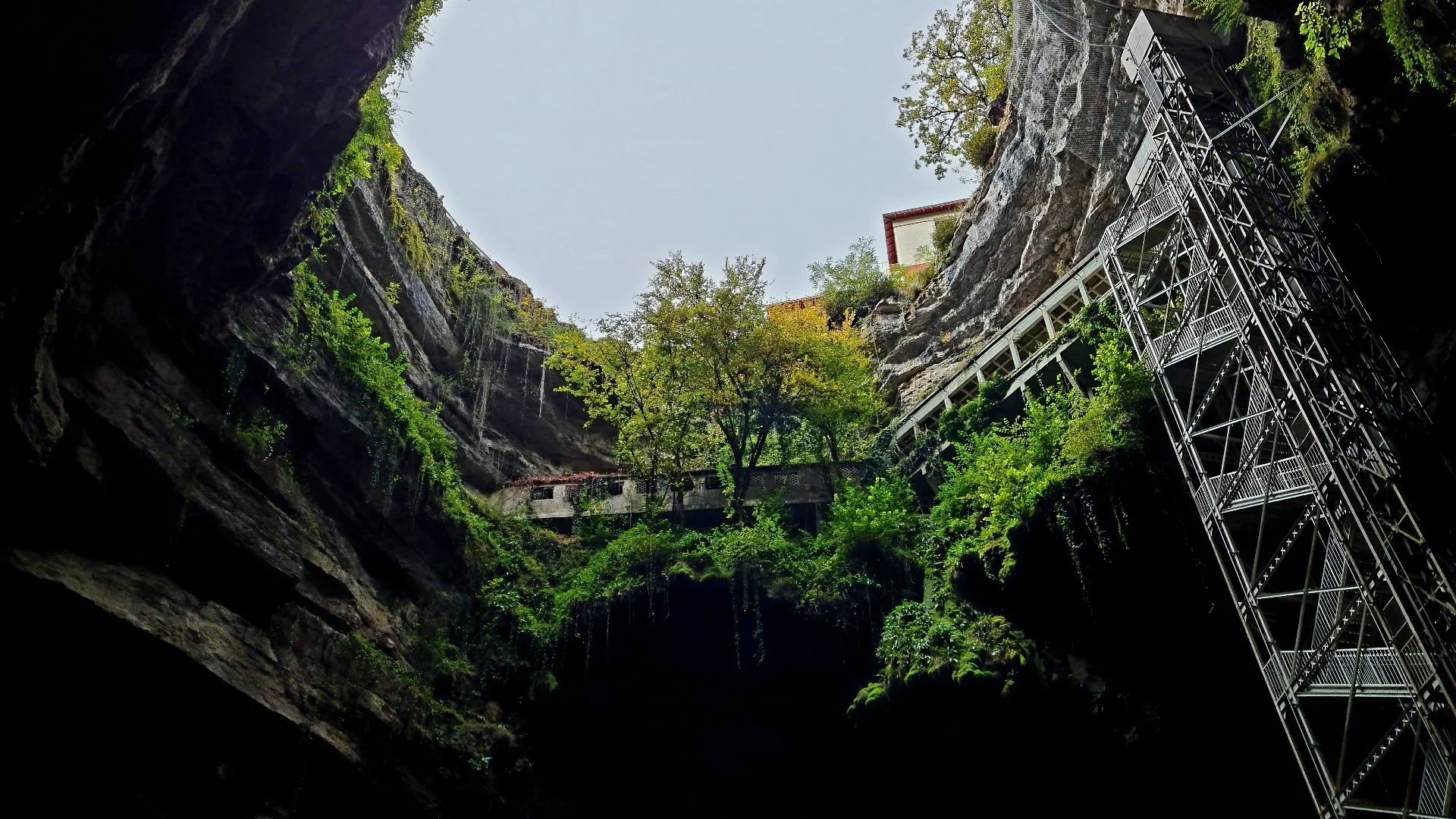 A picture of a huge cavern at Padirac Caves looking from the bottom right up to the sky.