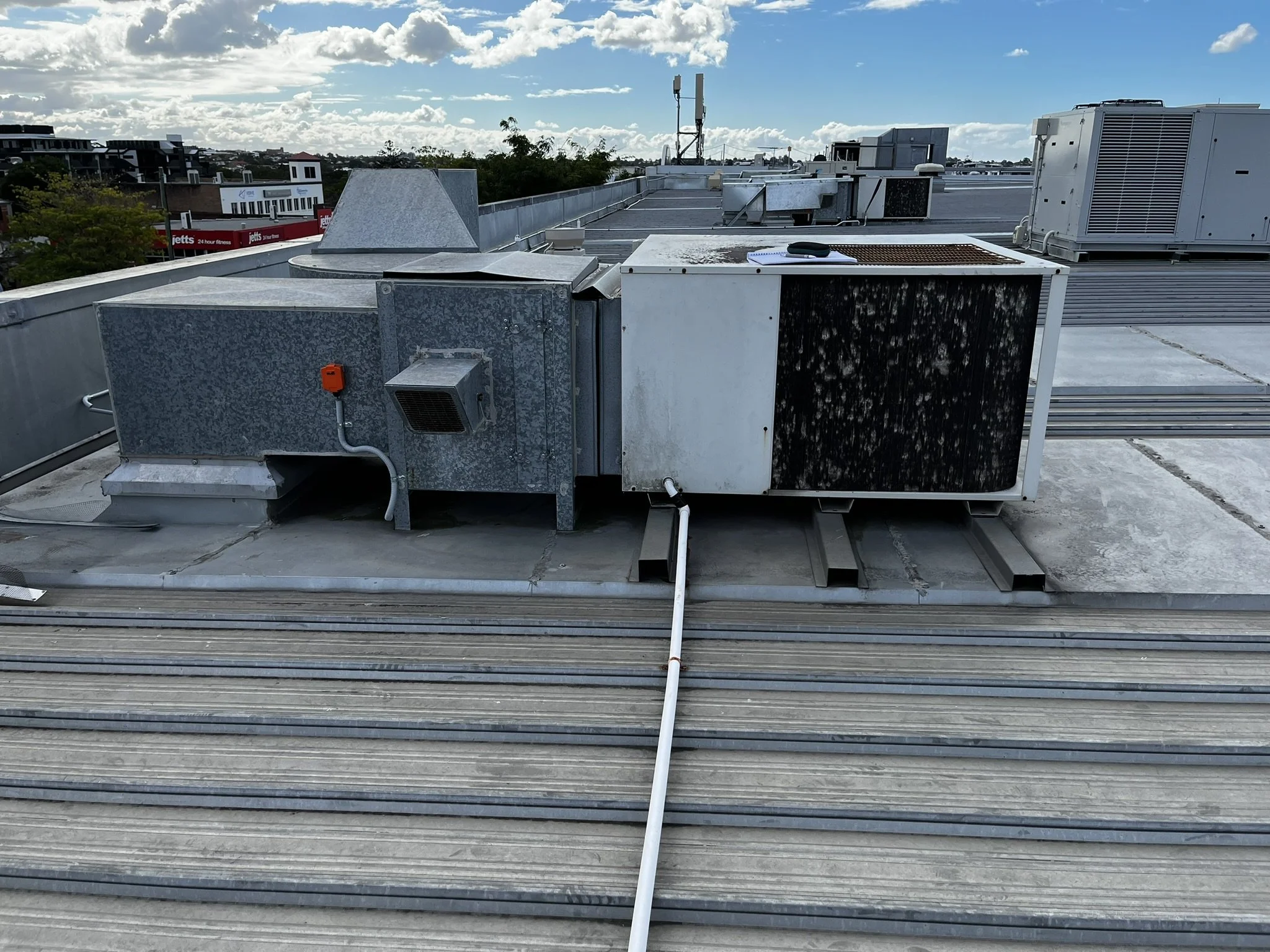 Rooftop HVAC unit against cloudy sky background