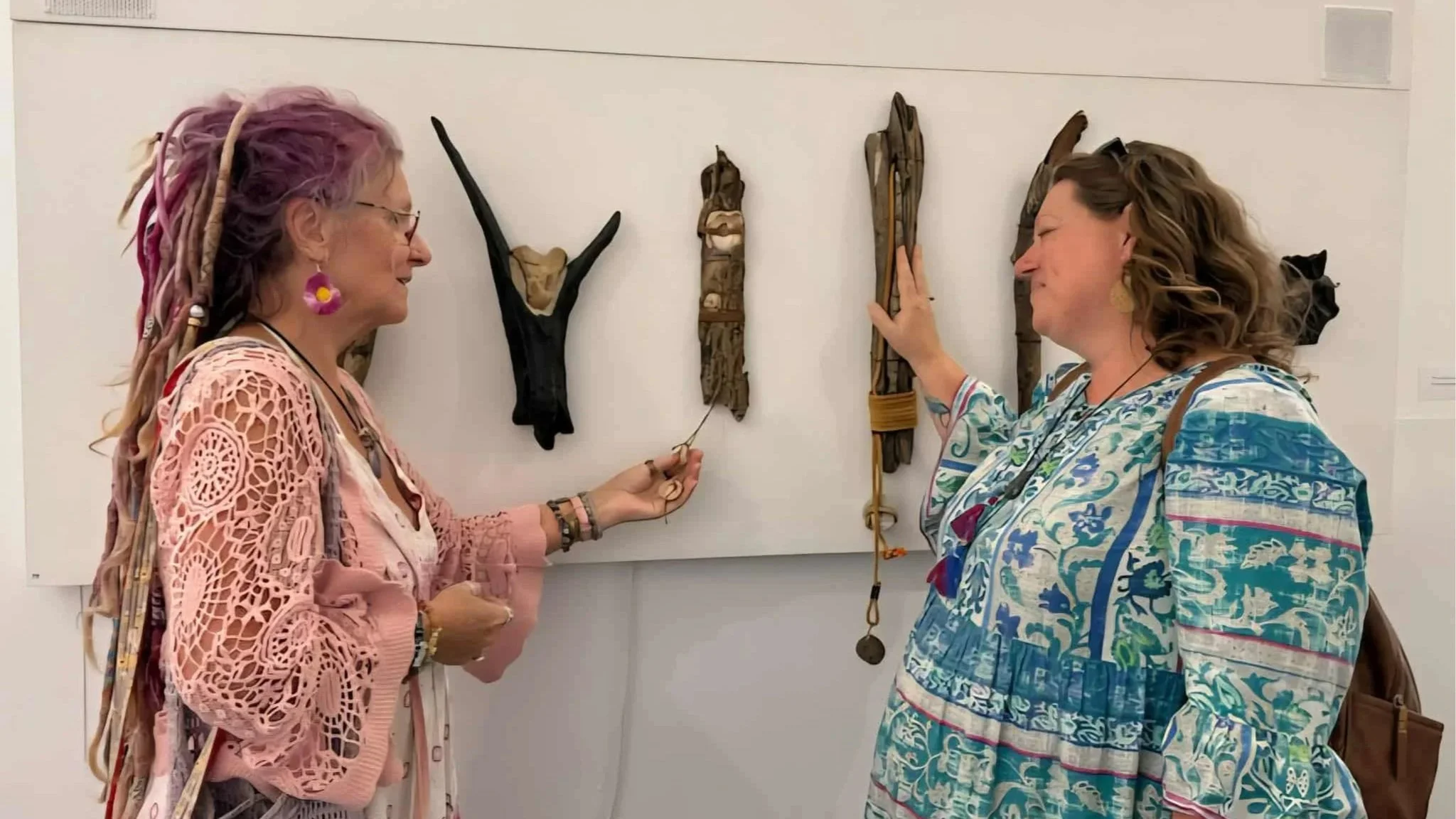 A colorful installation of open umbrellas suspended in the air against a bright sky, featuring shades of yellow, orange, red, pink, green, blue, and purple.