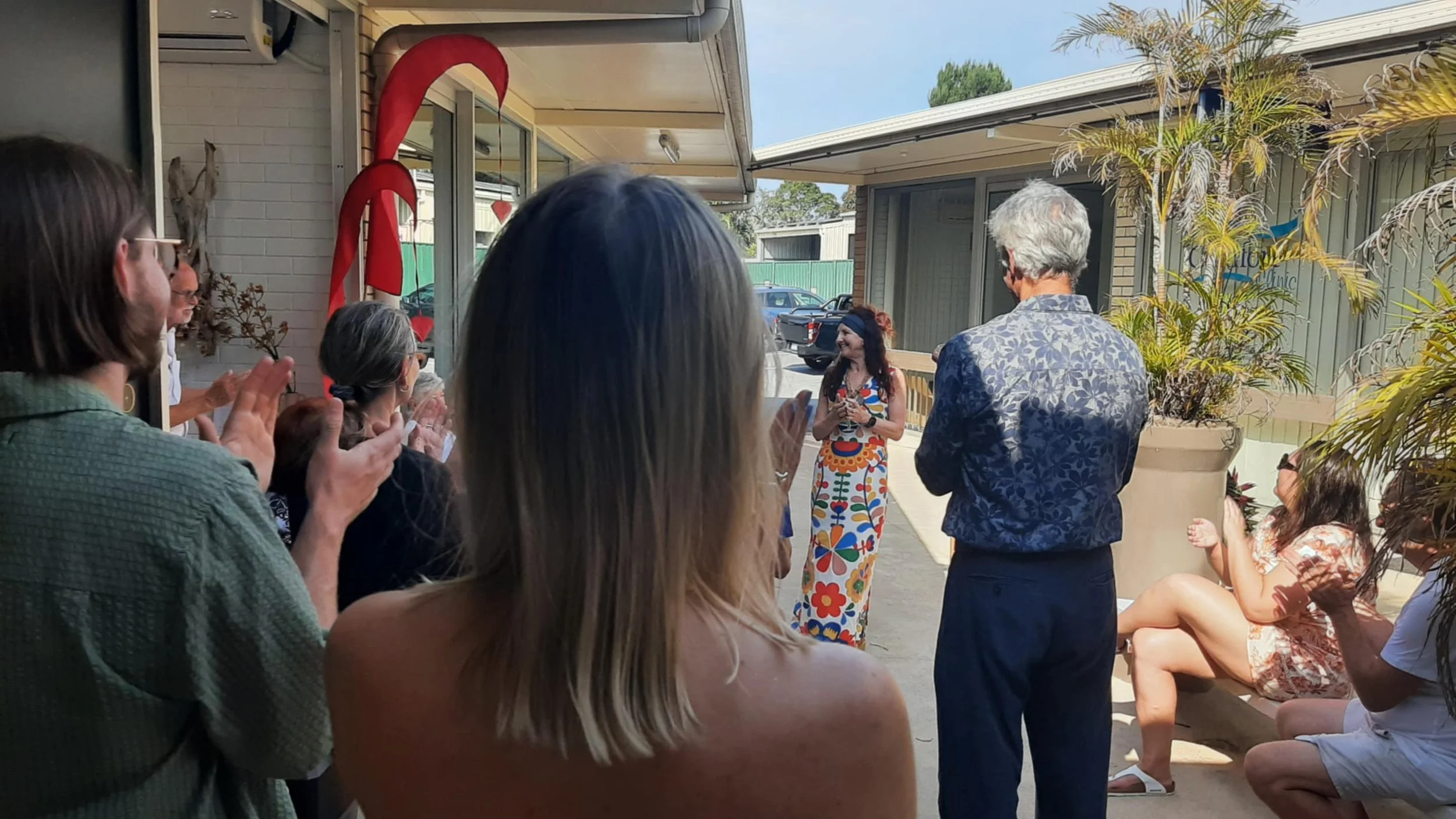 On a rooftop at dusk, wires are illuminated with light trails creating abstract patterns, with a colorful sunset and starry sky in the background.