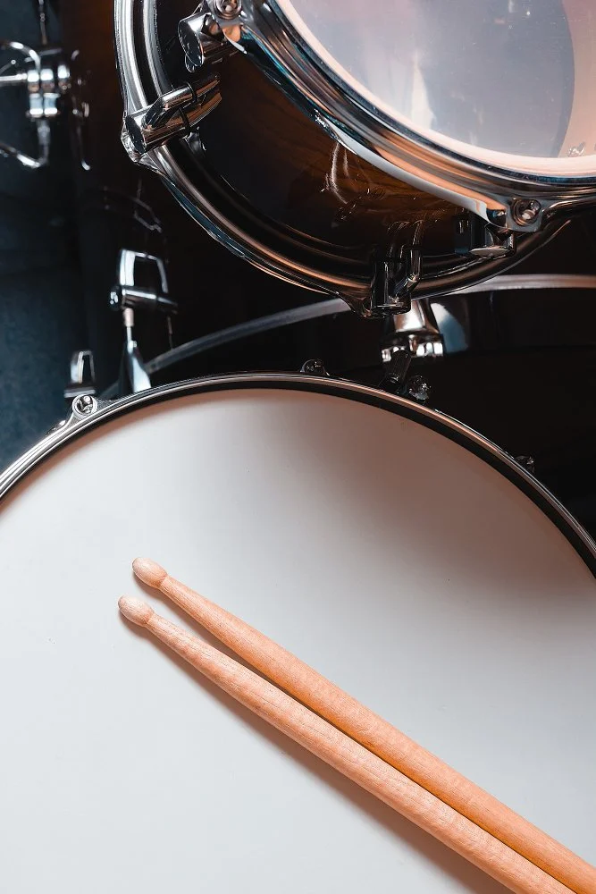 Close-up photo of a drum set with drumsticks resting on the drumhead for Sunnyside Homeschooling's StarJam Homeschool Music Program