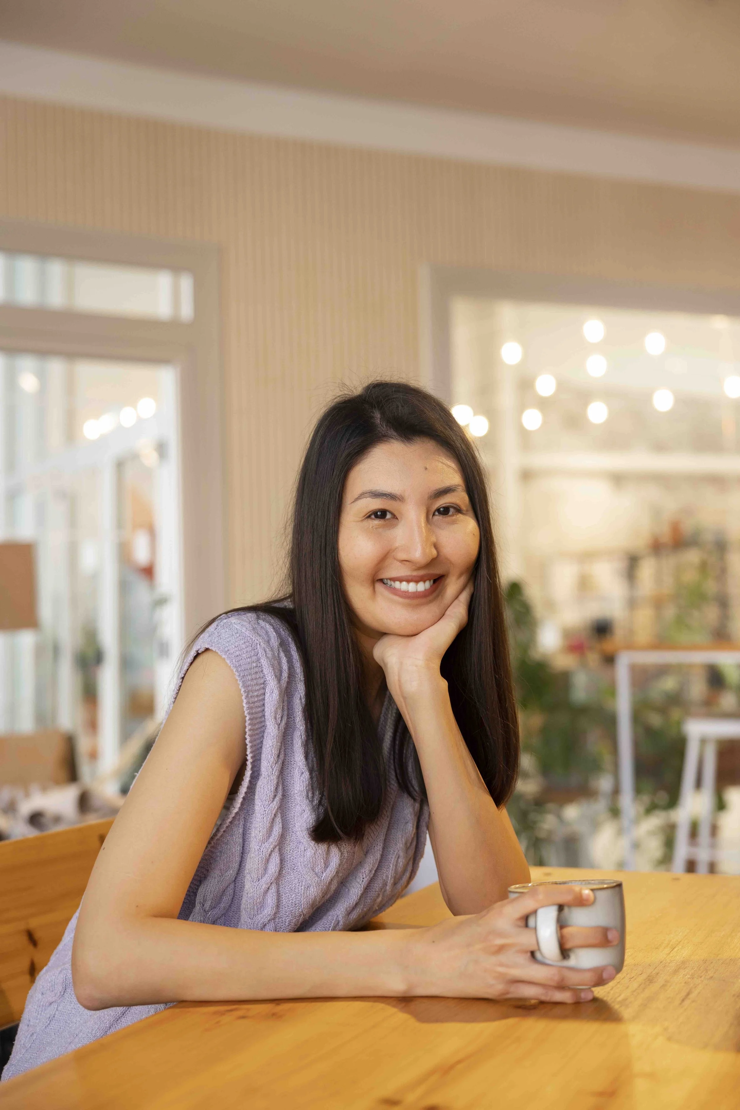 Sunnyside community member smiling while enjoying a drink indoors