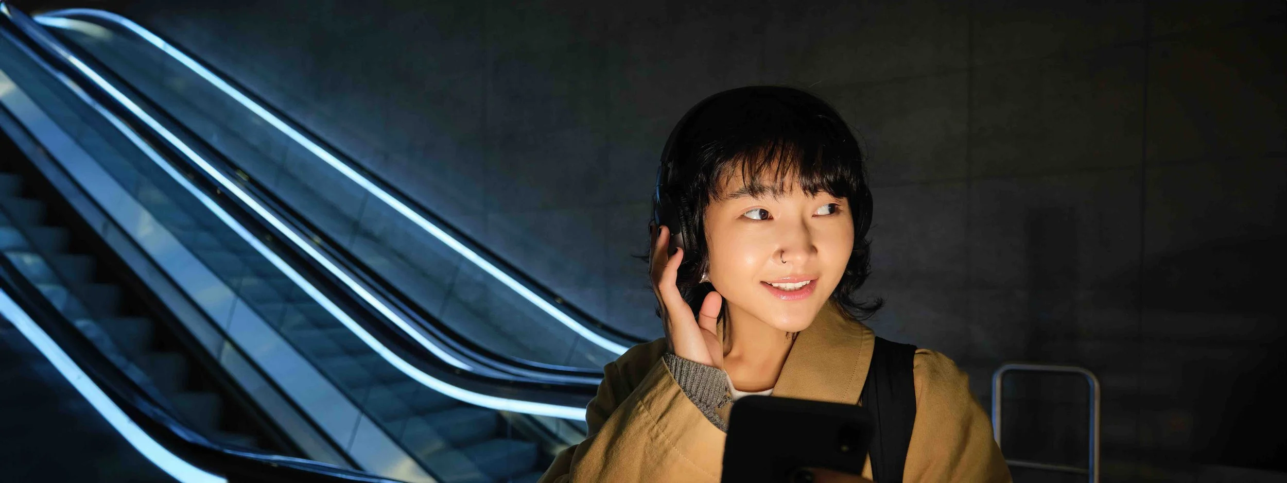 Sunnyside illustration of a young person listening to headphones while using a phone
