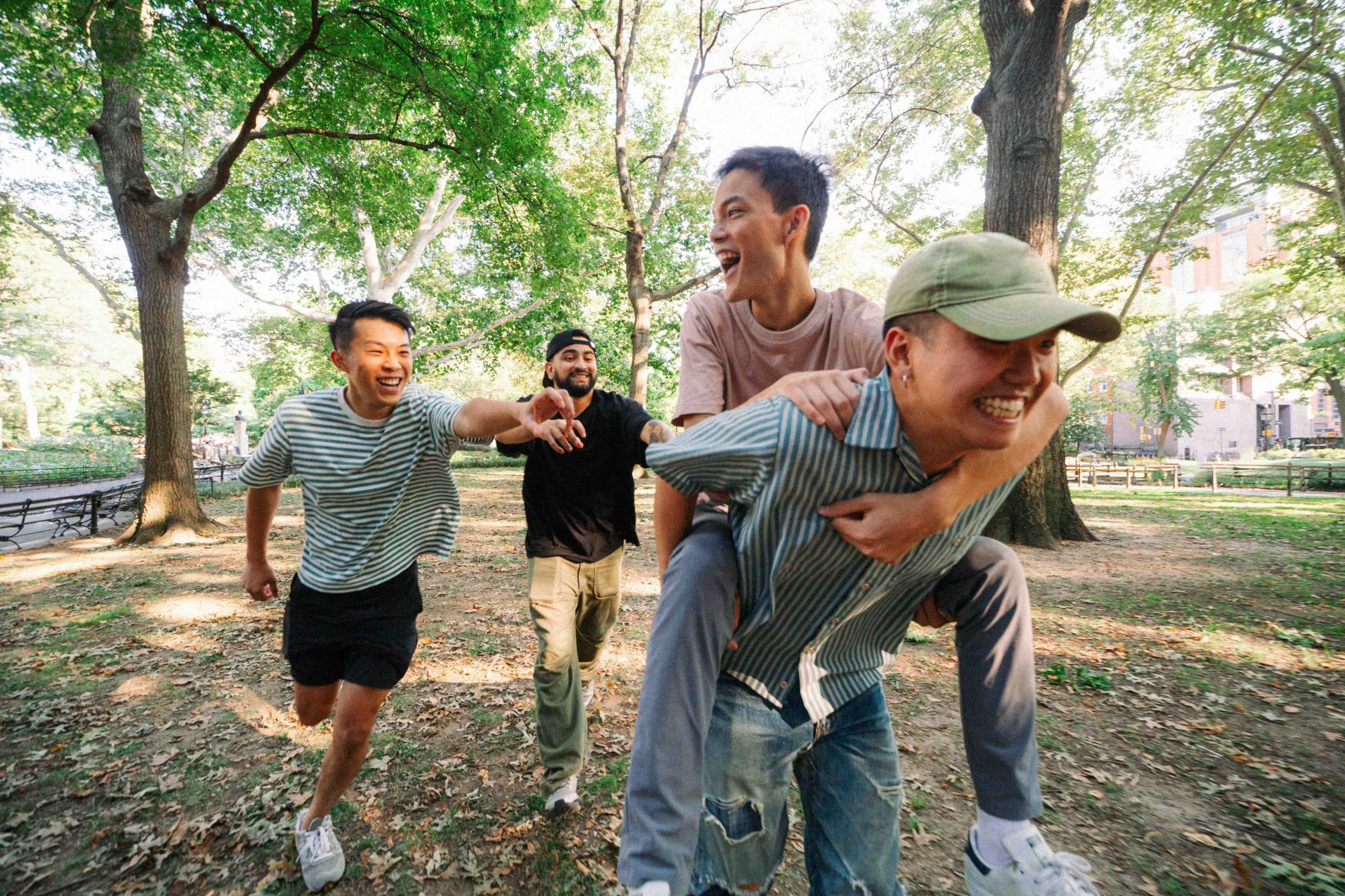Sunnyside friends enjoying a piggyback race in a park