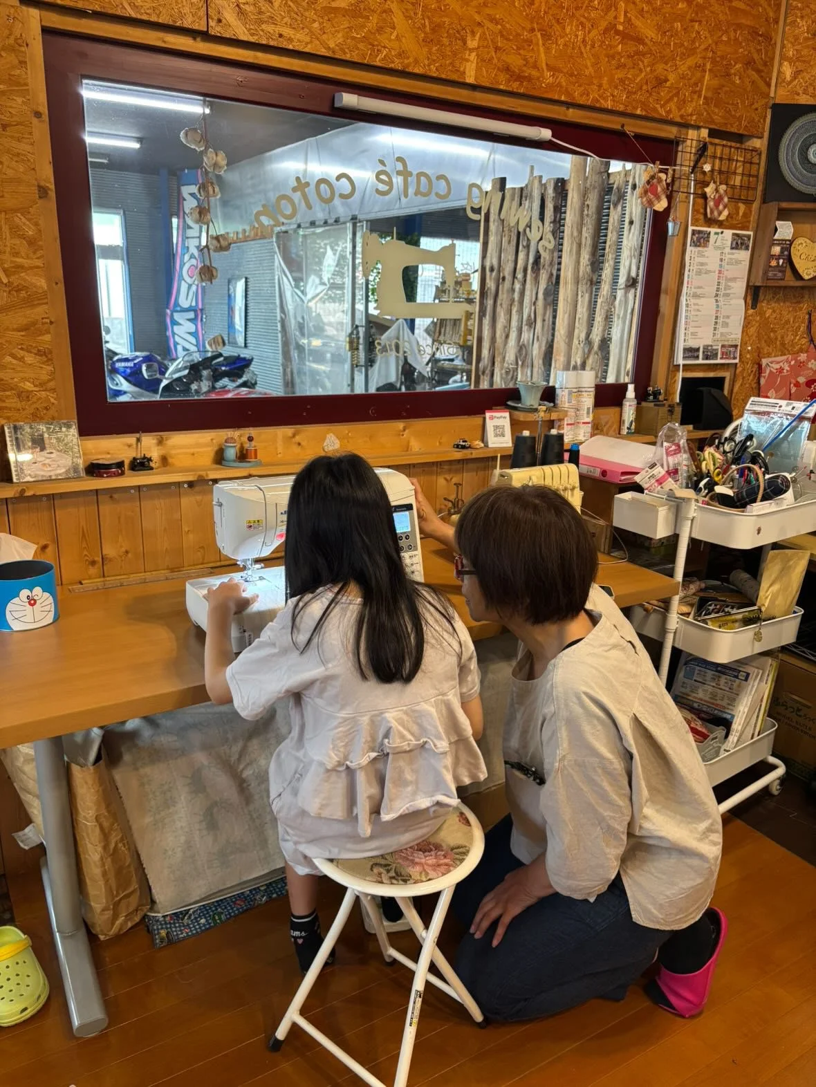 子供と講師がミシンを使って洋裁をしている店内の様子。