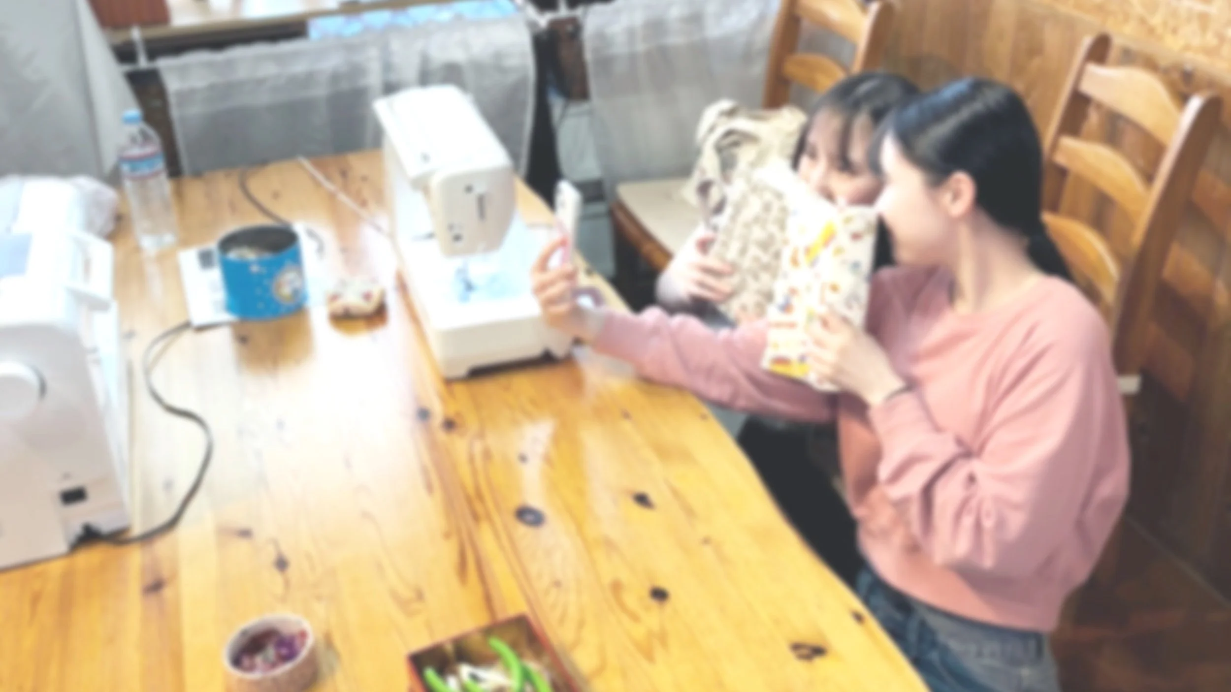 ソーイングサポートを終えた女の子ふたりが、完成した作品と一緒に記念に写真をとっている。