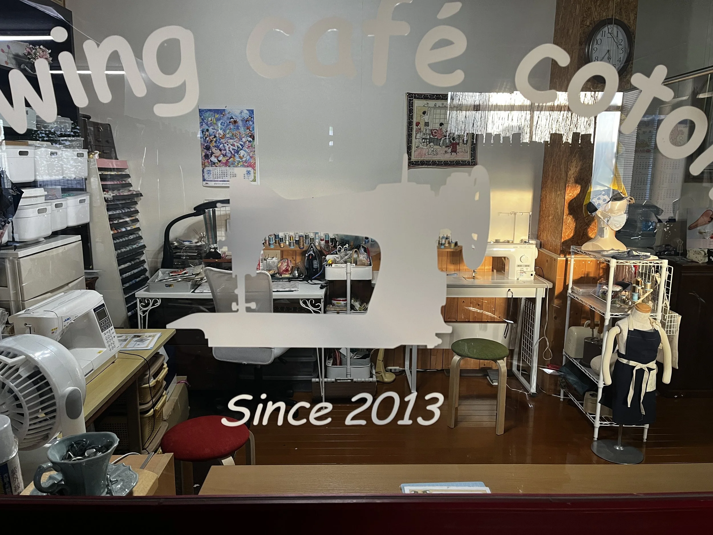 アトリエ店内の様子。ミシンや裁縫用品、 トルソーや椅子が置かれ、壁にはアートやカレンダーが掛かっている。