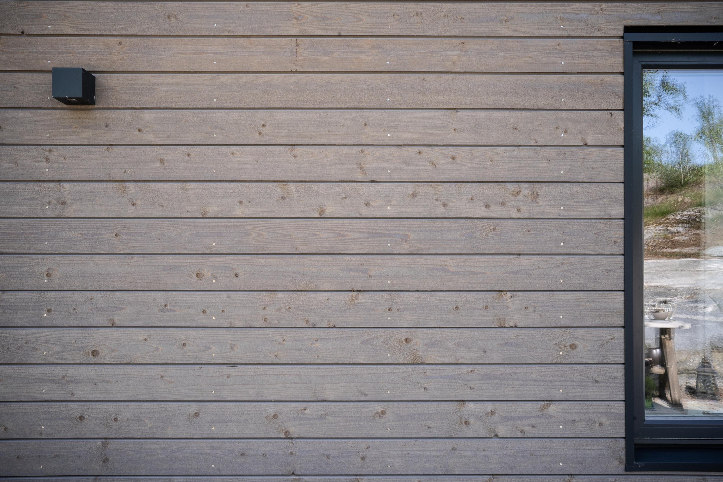 Träpanel av ett hus med en fönsterruta