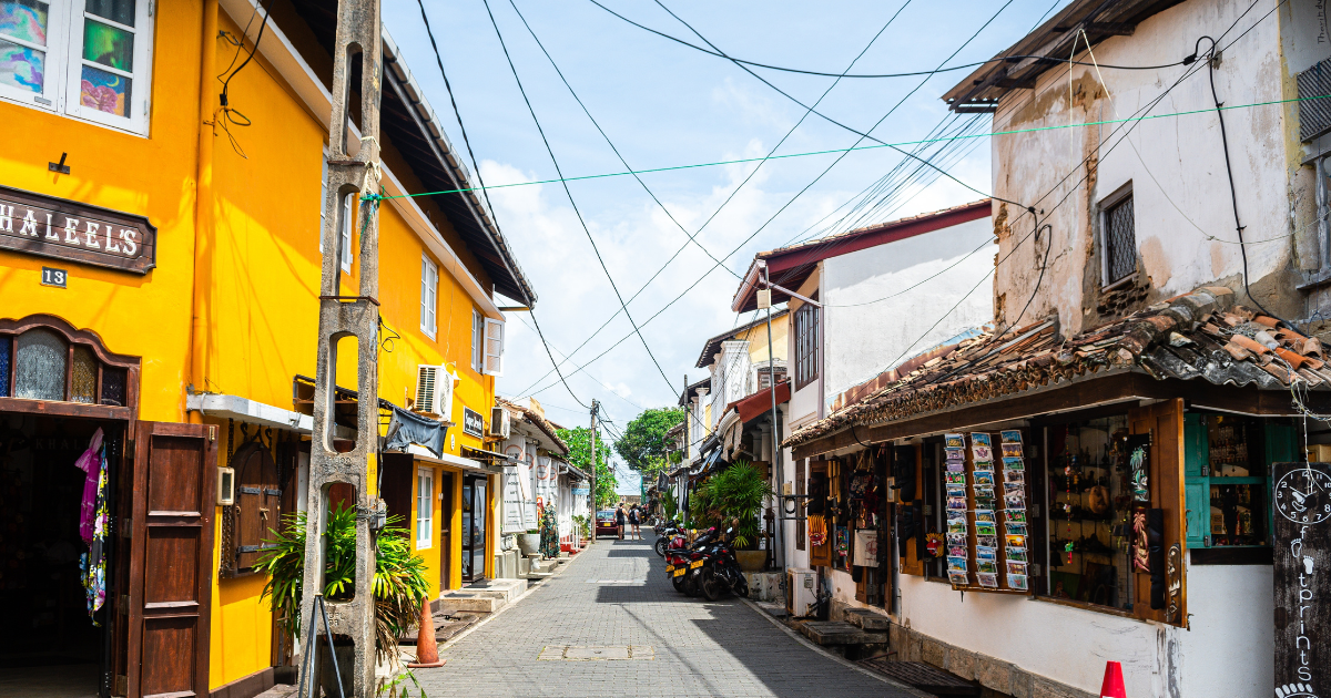 A narrow street inside Galle Fort lined with colourful shopfronts and colonial era buildings