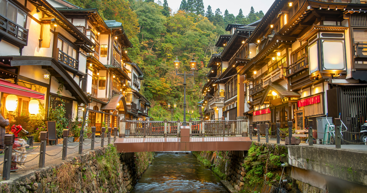 Traditional onsen town street with ryokan buildings and evening lights in Japan
