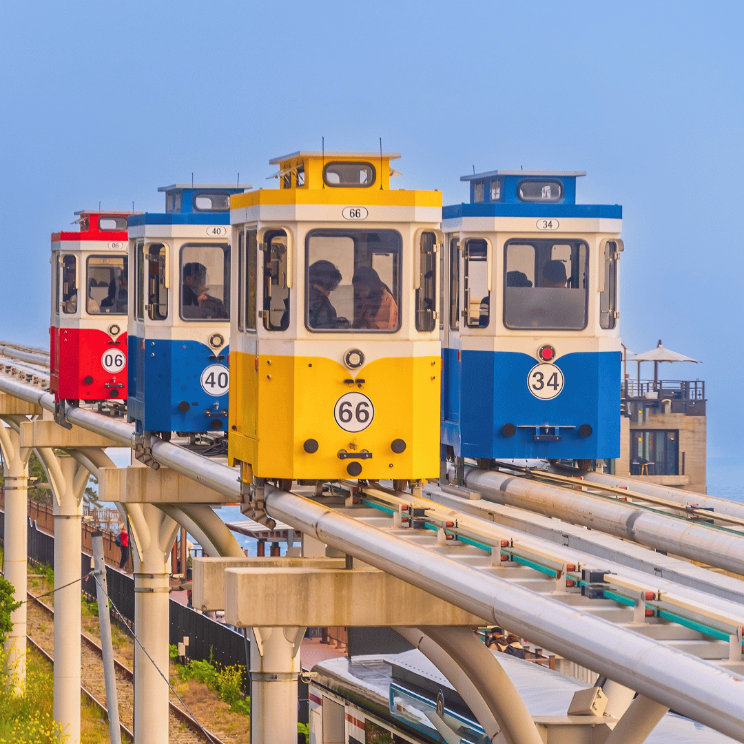 Colourful Sky Capsule train travelling along the coastline in Busan, South Korea.