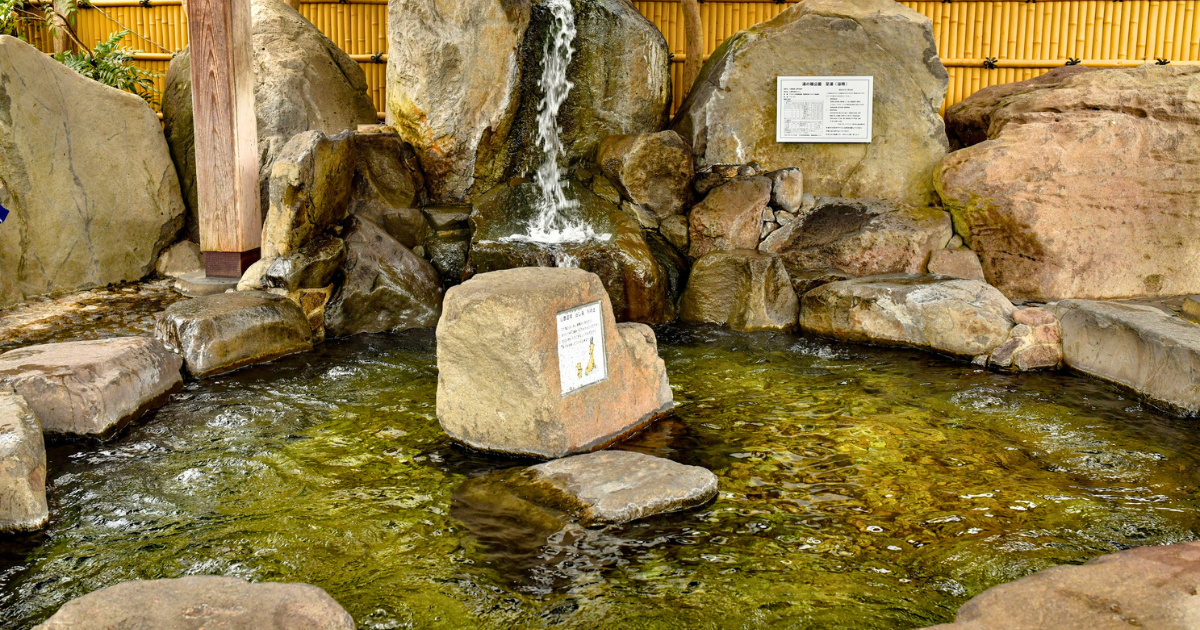 Hot spring water flowing into a stone onsen bath in Japan