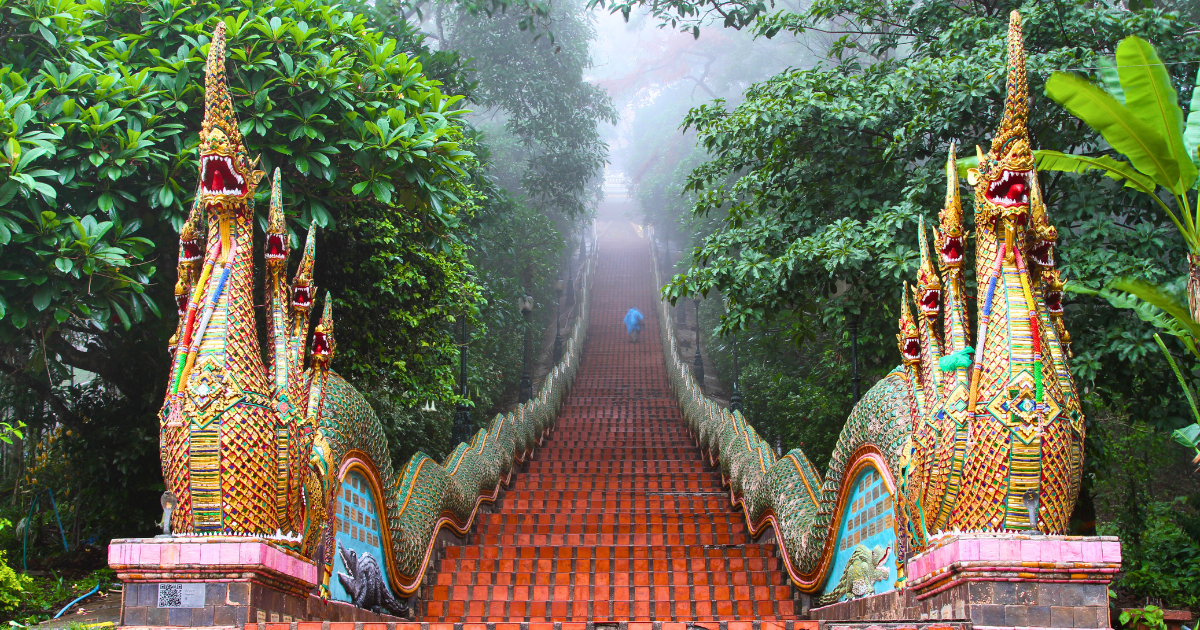 The Naga staircase at Wat Phra That Doi Suthep rising into mist between serpent balustrades