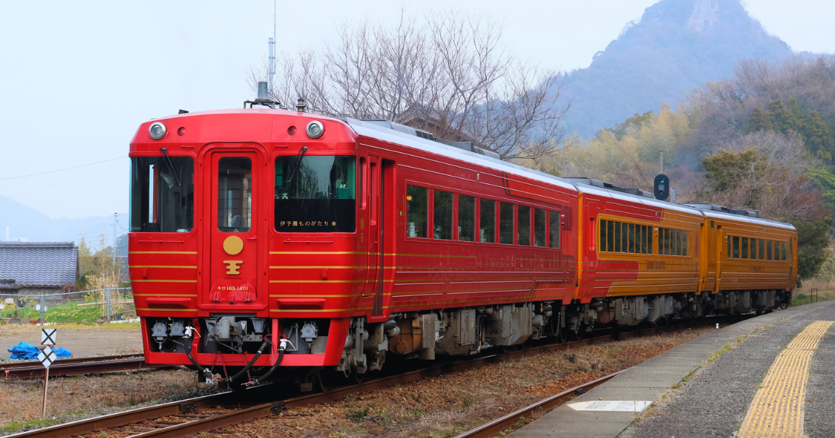 The red and gold carriages of the Iyonada Monogatari sightseeing train at a station in Ehime