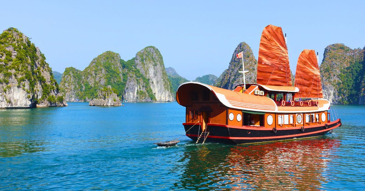 A traditional junk boat cruising through the karst islands near Cat Ba.