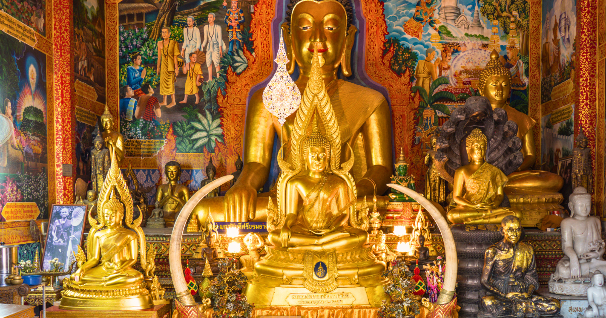 Golden Buddha images and founding legend murals inside the viharn at Wat Phra That Doi Suthep