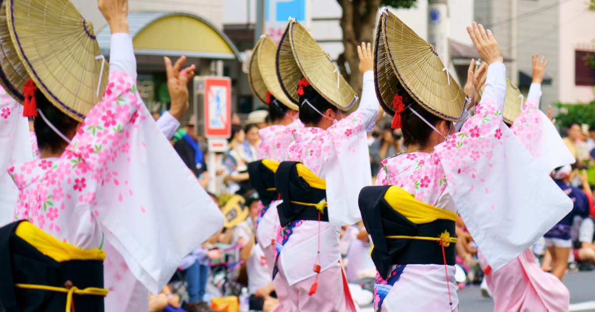 Dancers in pink and white yukata wearing woven straw hats during the Awa Odori festival