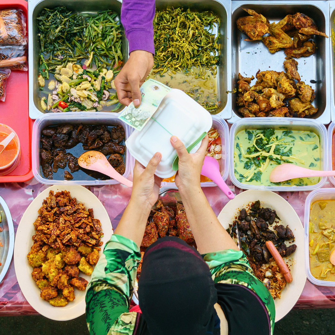 Traditional Malaysian Borneo buffet featuring a variety of local dishes, vegetables and curries at a market-style food stall in Kota Kinabalu. 