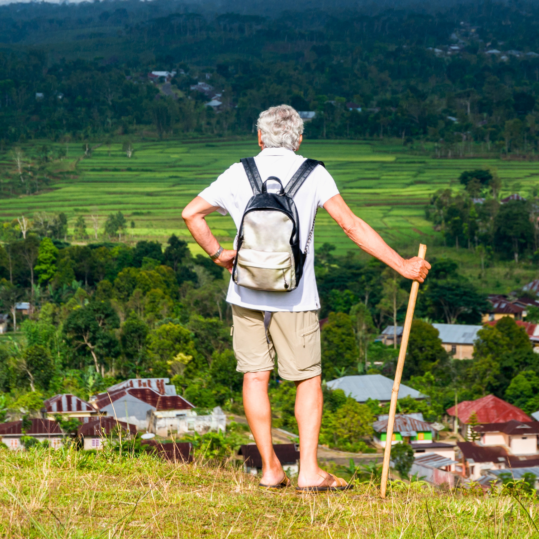 A traveller overlooking the mountain villages and rolling landscapes of Flores during a guided walk on our Indonesia small group tour.