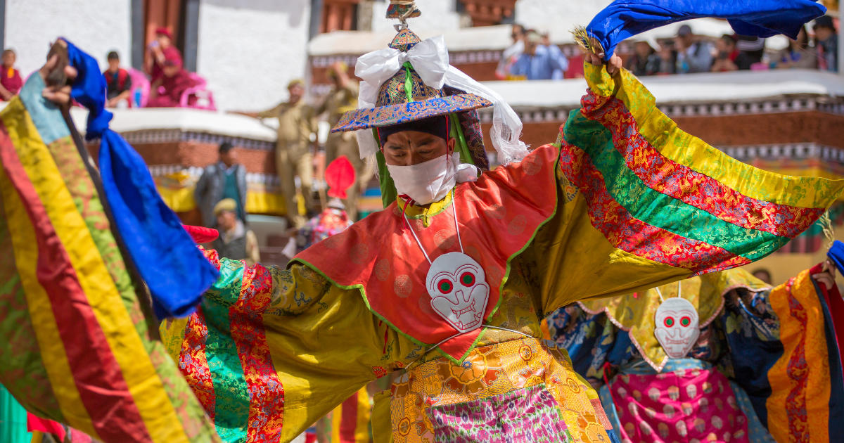 Cham dancers in colourful brocade robes performing at Hemis Festival in Ladakh.