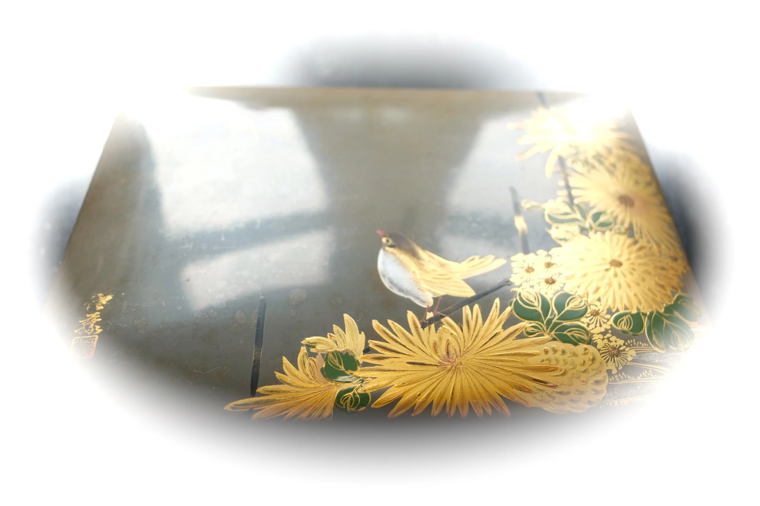 Une surface décorative avec un motif floral et un petit oiseau peint, entourée d'un contour flou