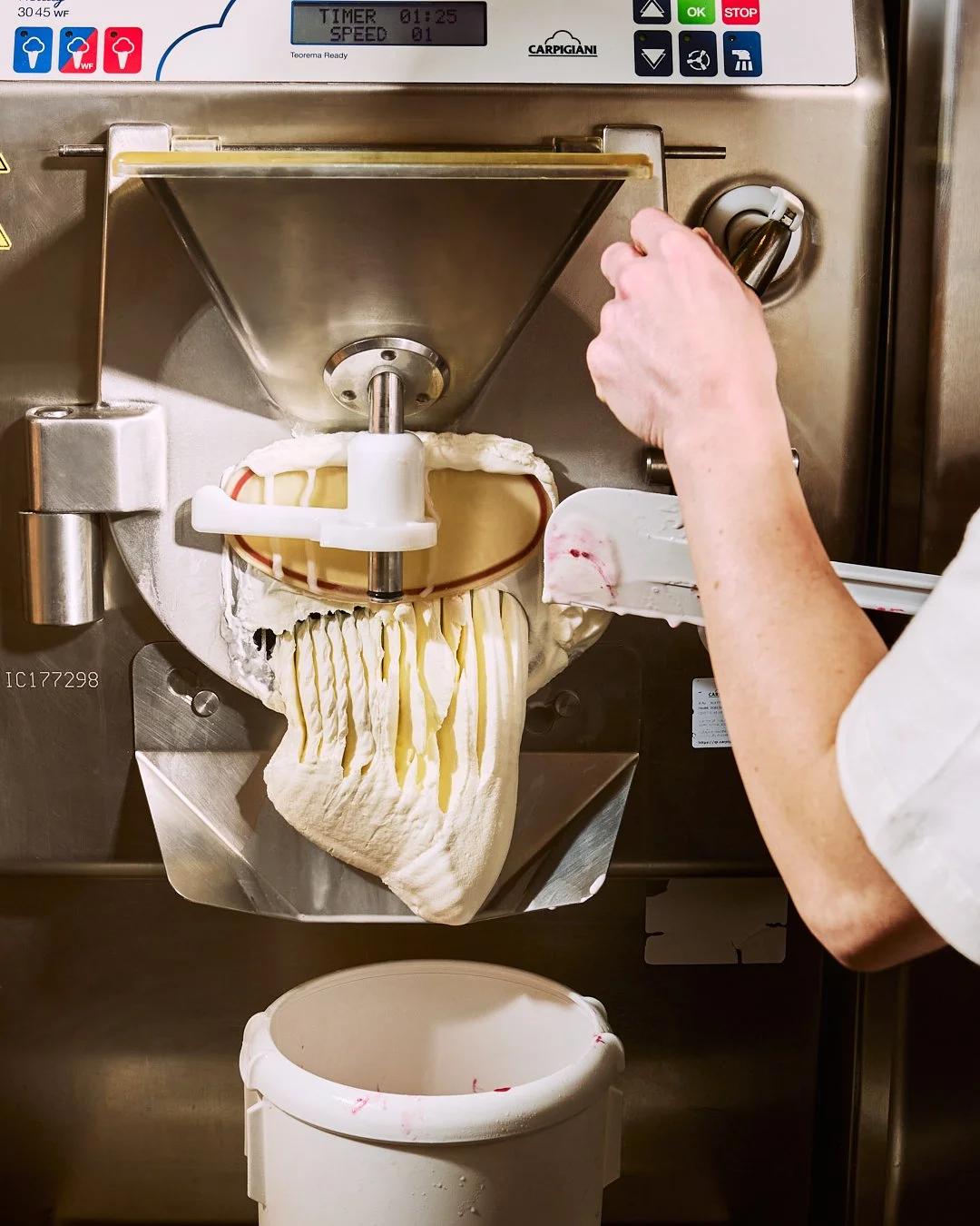 Spouse Studio. Gemma Tree. A person using an industrial gelato or ice cream machine to make ice cream, with a large cone of soft ice cream being extruded into a container below.
