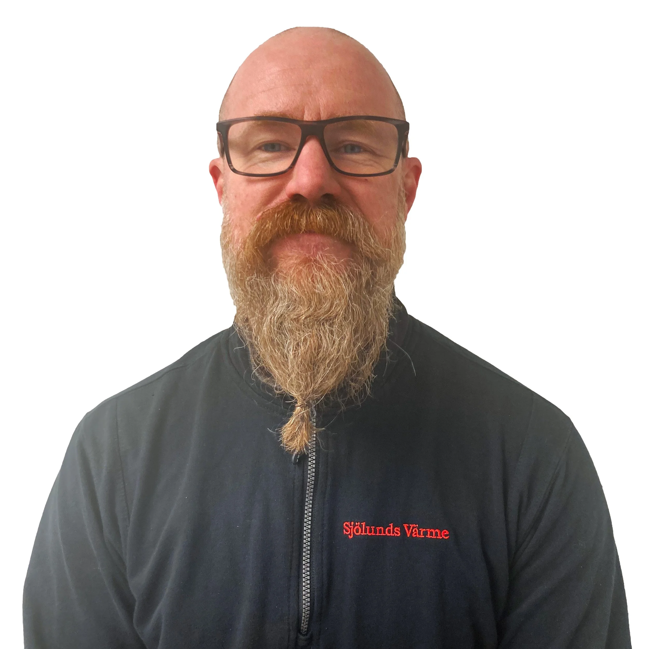 En man med skägg och glasögon, bär en svart jacka med texten 'SjöLunds Värme' på.