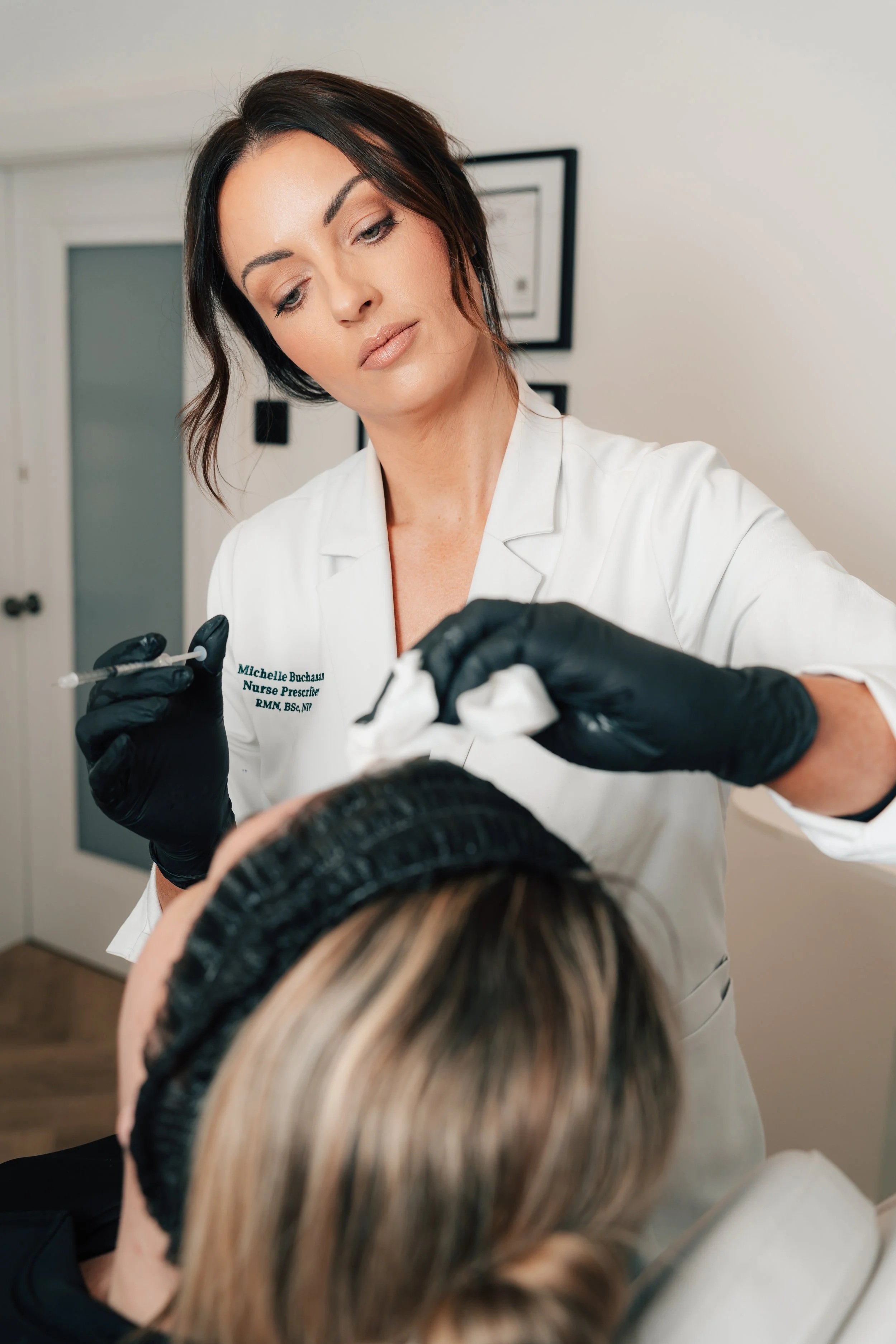 Healthcare professional preparing a patient for an cosmetic facial injection in a clinical setting.