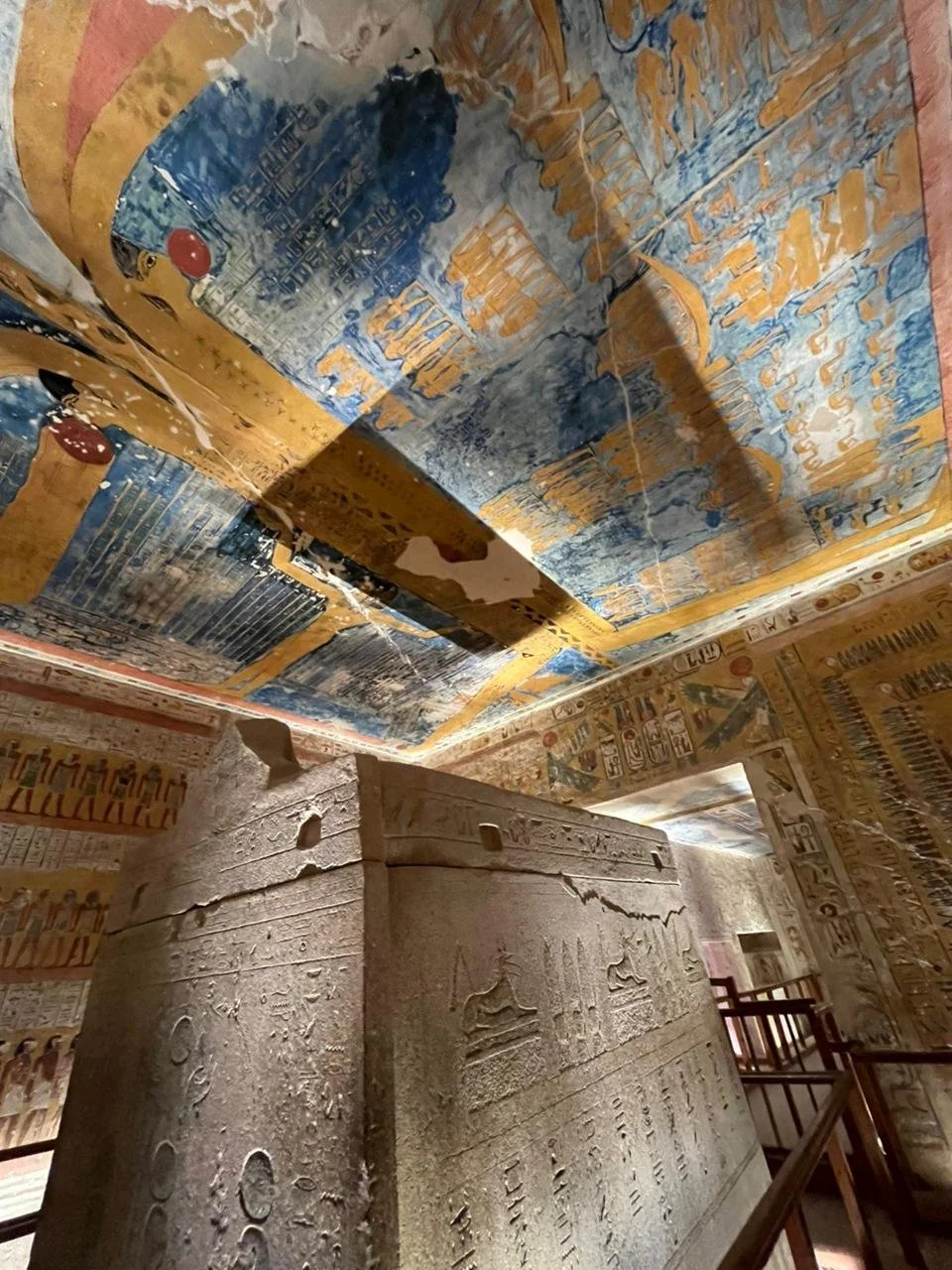 Ancient Egyptian tomb with hieroglyphic inscriptions and colorful wall and ceiling paintings.