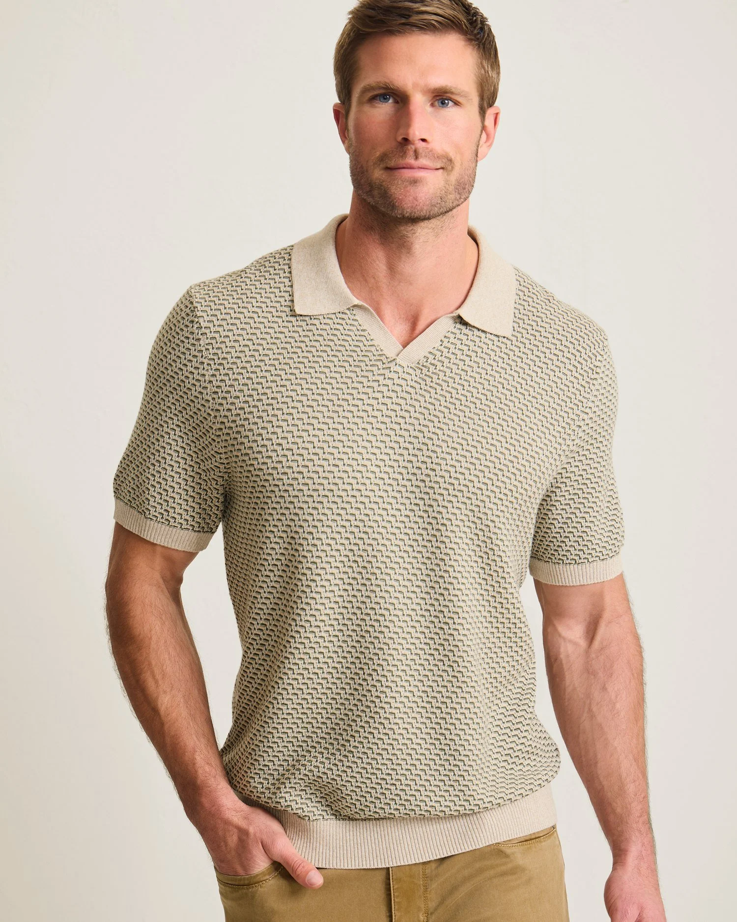 Man wearing a beige patterned short sleeve polo shirt and khaki pants.