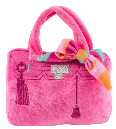 A pink plush handbag with a colorful bow accessory on the handle.