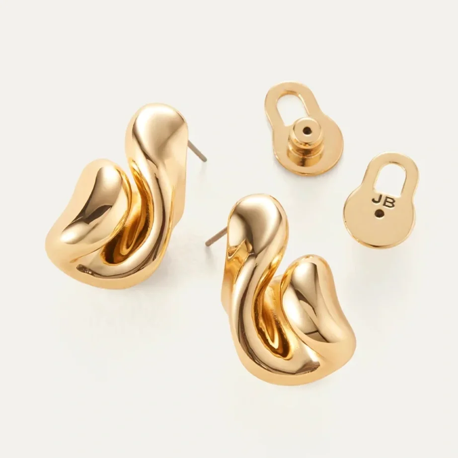 Gold knot-shaped earrings with removable backings, one marked with initials 'JB'