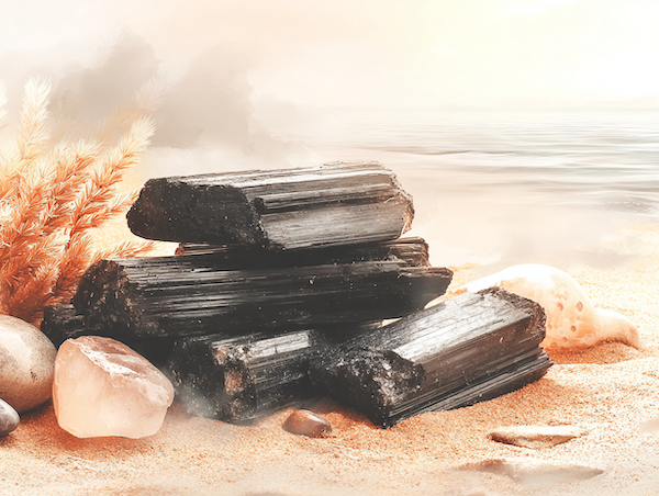 Zwarte toermalijn op zand als symbool voor bescherming en aarding