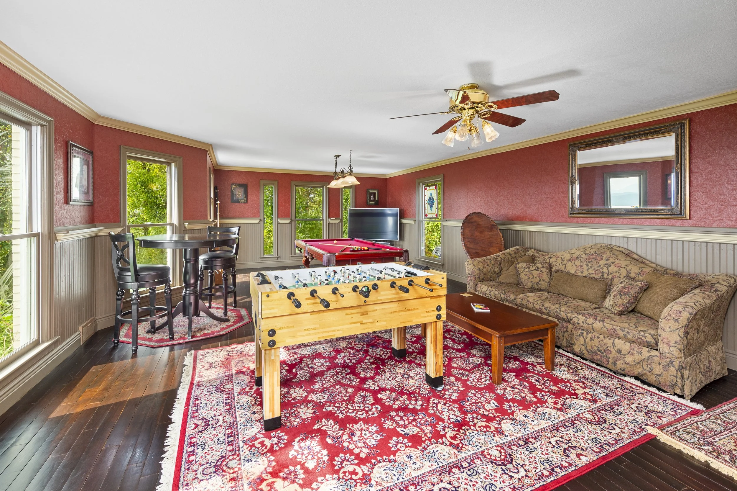 Game room with foosball table, pool table, sofa, and TV.